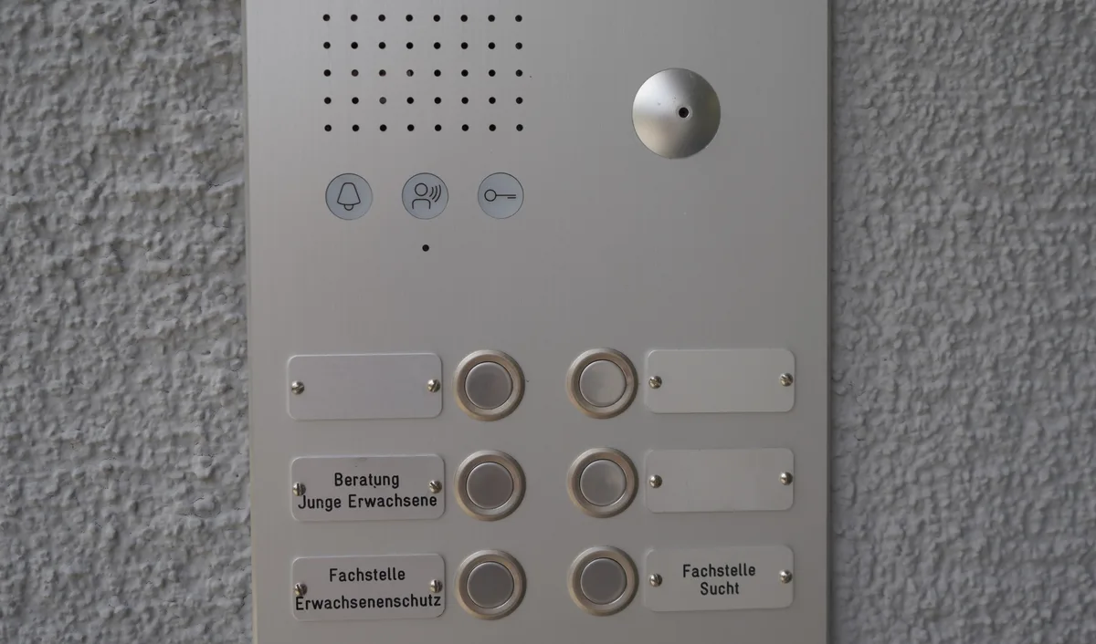 Klingelschild an einem zweistöckigen Bürogebäude.